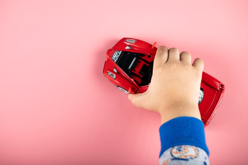 Child playing with toy car