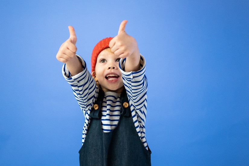 Happy child showing thumbs up